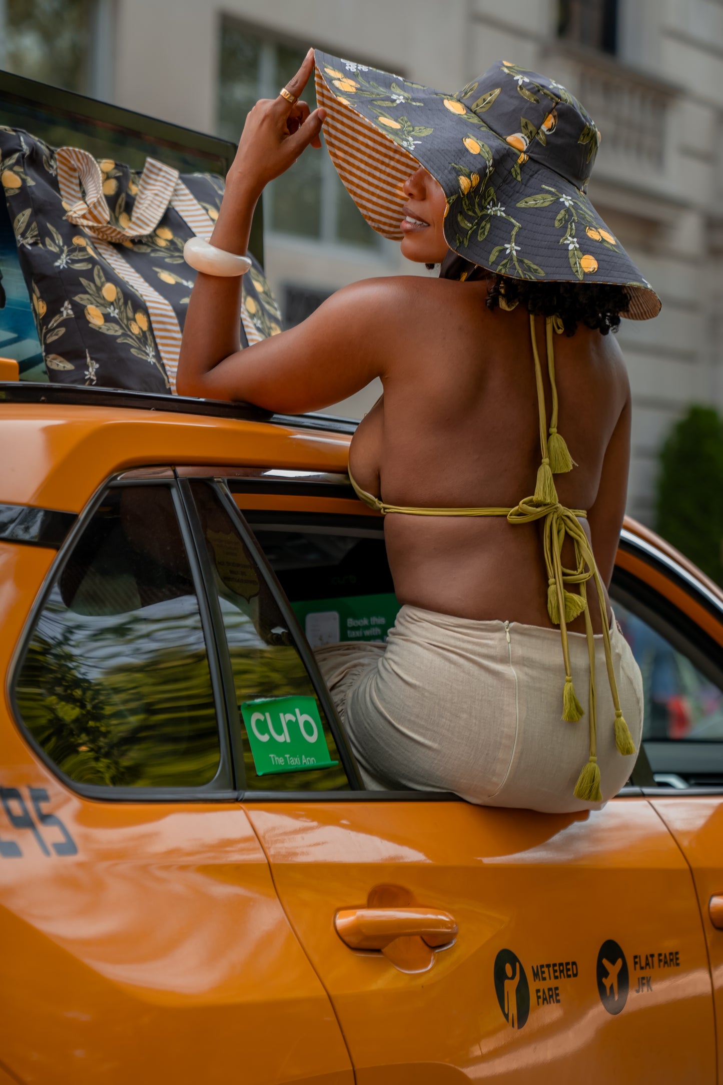 eversible wide-brim hat with lemon print on one side and tan stripes on the other